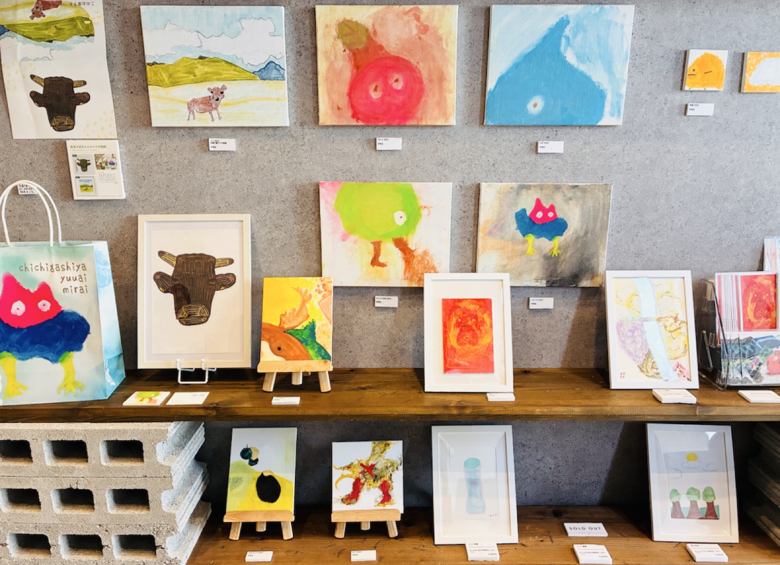 角田みらい展の会場全景・カフェMABONOの壁面に並ぶ作品